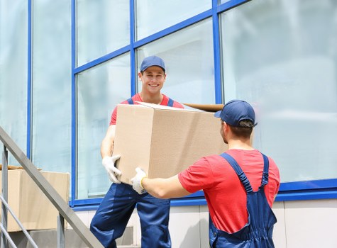 Professional movers loading household items into a van in Westcombe Park