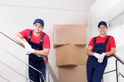 Movers transporting office furniture through a Westcombe Park building