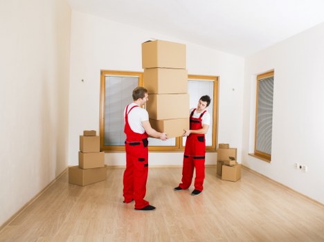 A sustainable moving team separating cardboard, wood, and plastics for recycling